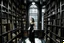 Placeholder: full-height shot of a woman in a tight black dress, inside a large magic book shop, books, bottles, windows