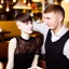 Placeholder: Russian guy boyish boylike short man's haircut boyish features in black girlish lacy cocktail dress in restaurant