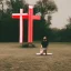 Placeholder: person kneeling in front of a huge cross