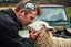 Placeholder: a portrait of a broken head mechanic, kissing a hybrid mixed body part sheep, fixing (far away old land rover 4x4 discovery 2) in the countryside