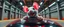 Placeholder: car driving happy 2d neon fluffy orc racer rat with human hands in the style of Escher and Giger and Fallout 4, pinhole cam, airbrush 3d rendering, on tv screen:A five-second cinematic single take in a clean industrial presentation hall.
