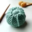 Placeholder: flower-shaped wool ball, crossed by two crochet hooks. front view. bottomless.