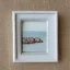 Placeholder: tiny oil painting of tiny seaside village, plain white background, solid white background, tiny white canvas, tiny white frame, melancholy, tender, moody, vintage, delicate arrangement, beautiful composition, etsy, aesthetic layout, plain solid white background