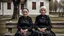 Placeholder: gloomy-looking old women sitting in black villager dress and wearing east european black head scharf on wooden bench in front of white old house outside in an authentic east european village, high detalied, professional photo, high qualit, high textures. The high-resolution image captures the essence of authenticity and realism, transporting the viewer to another time and place.