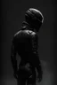 Placeholder: Background is dark grey, almost black. There is a head and torso silhouette looming in the picture, completely masked by a black motorcycle suit.