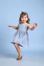 Placeholder: a pretty 5 years old girl with blue eyes and nice dress and shoes dancing and playing joyfully