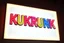 Placeholder: A 1980 disco sign labeled "KUKRUNK" white background and bold multi colored 80s font, miami vice