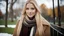 Placeholder: Professional high photography photo, young 19 year old caucasian woman wearing a winter coat and scarf. She has long blonde straight hair, low angle, seductive smile, sexy, earrings, in a park during the Fall, detailed face, dark theme, daytime, soothing tones, warm colors, high contrast, (natural skin texture, hyperrealism, soft light, sharp), (freckles:0.12), (acne:0.12),