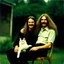 Placeholder: Awkward portrait Photo, old and young sitting on chair, weird smiling, long 1970 hair and mustasch, polaroid camera, holding a cat