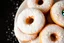 Placeholder: background filled with fresh mini donuts powdered in icing sugar