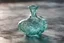 Placeholder: mint color tone, A beautifully crafted clear glass chess piece, intricate details and swirls, reflecting light around its surface, with a delicate heart, perfectly fitting inside its design