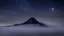 Placeholder: one single mountain sharp face rises out of the mist into the night sky.