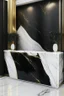 Placeholder: Black reception desk with white marble wall veined with gold