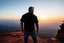 Placeholder: a brawny man with grey hair views sunset from a cliff