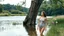 Placeholder: a beautiful lady in nice swim suit in river in country side next to river and big tree,wild flowers standing