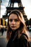 Placeholder: Mujer joven mirando hacia la cámara en una calle de París con la torre Eiffel de fondo.