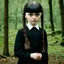 Placeholder: Young lily-rose Depp as Wednesday addams, braids, bangs, in tge woods