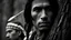 Placeholder: the back of a 30 years old native american in the early 19th century on a sunny day, he has medium dark hair, the native american is spying behind a tree in the forest, the native american is hidding behind a tree, the native american is dressed with furs and has hawk feathers in his hair, black and white mood, film noir, high density, high contrast and grain, frontal view, long shot, from seven samurais by Akira Kurosawa