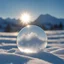 Placeholder: Frozen bubble in front of a snowy mountain landscape, the bubble has wonderful icecrystals and the sun is shining, frozen, cold outside, beautiful small ice flowers in front of the bubble