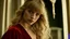 Placeholder: Photo is in sharp focus with high resolution during the middle of day and is a closeup of a beautiful and slender caucasian 16 year old girl with long wavy blonde hair and bangs. She has a small upturned nose, full lips, large dark eyes and with long eyelashes. She is wearing a red silk evening gown. She is in a castle room gazing at the viewer.