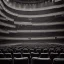 Placeholder: a single chair on stage under spotlight close up view facing empty audience at a dark and empty symphony hall