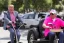 Placeholder: Photo of a single donald trump riding a tricycle while wearing a pink polo shirt with the collar up