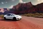 Placeholder: A Tesla 'Model Y' is going at a high speed, in the 'Grand Canyon National Park'. (CINEMATIC, WIDE ANGLE LENS, PHOTO REAL)