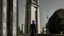 Placeholder: a big man in a modern street in Tehran with a tower.