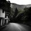 Placeholder: A photography depicting a street going up to a moutain, with odd houses, horror movie shot, terrifying trees