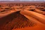 Placeholder: a grand chocolate mountain very melting in the sahara, hot, suny day