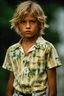 Placeholder: 12 year old young boy with lightly tanned skin and short sandy blonde hair, scowling, wearing a shirt, inside