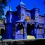 Placeholder: A purplish periwinkle haunted mansion with spirits designed in African masks painted by Andy Warhol