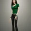 Placeholder: Woman with crook, back, black trousers, green shirt, render background, brown hair