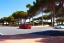 Placeholder: Day in quinta do lago, main avenida with two luxury car, with red cycling lane on both sides