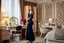 Placeholder: very beautiful sexy lady with beautful dark blue midi skirt and blouse standing in a luxury bedroom with high heels next to makeup desk looking to camera