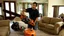 Placeholder: man uses chainsaw on brand new couch in living room