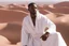 Placeholder: african man wearing white thobe. standing on high mountain looking out to the desert