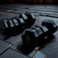 Placeholder: Hexagon dumbbells pair of two, each 12.5KG. Inside a gym on the black rubber tile floor. Bird perspective on the dumbbells laying on the floor.