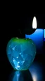 Placeholder: Chrystal Apple with a bluer view of candle behind it , a tiny star on the dark background behind