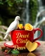 Placeholder: hyper realistic image of a glossy shiny vibrant red large cup of coffee with steam , a beautiful white dove sitting near the cup and holding a yellow rose, and the text 'Dewi Cinta' in a stylish font. Add a golden heart with the word find detail 'Dewi Cinta' written on it to enhance loving atmosphere. background blur lush greenery green waterfalls , ultra HD 64k hyperrealism studio lightning light reflection macro photography sharp focus