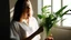 Placeholder: Woman holding a plant in the sunshine, interior, white shirt, instagram.