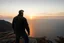 Placeholder: a brawny man with grey hair views sunset from a cliff