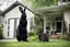 Placeholder: Photograph of an 8 foot tall black rabbit standing next to a house