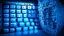 Placeholder: The image closely depicts a computer keyboard secured with a complex digital lock. The blue and white colors reflect the technological and security aspects of the subject. As an expression of digital protection and a focus on security in the era of digital communication, this image represents the balance between technology and personal safeguarding.