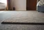 Placeholder: generate a closeup of a motel room floor, the carpet should show a rectangle that once clearly had a rug there