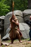 Placeholder: A Stone Age man holding a spear vs a modern man machine gun