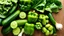 Placeholder: A close-up of a variety of green fruits and vegetables, including cucumbers, green bell peppers, and leafy greens, arranged artfully on a wooden table.