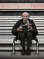 Placeholder: a protrait of a begger sitting inside a subway station in NYC. He is 80 years old, caucasion, thin with balding hair. In one hand he is holding a plastic cup and the other hand is stretched out to beg. Black and white photograph hyperrealistic photorealistic photography