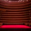 Placeholder: one chair on stage in spotlight close up view facing empty audience at a dark and empty symphony hall