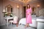 Placeholder: very beautiful lady with beautiful pink midi skirt and blouse standing in a luxury bedroom with high heels next to makeup desk looking to camera